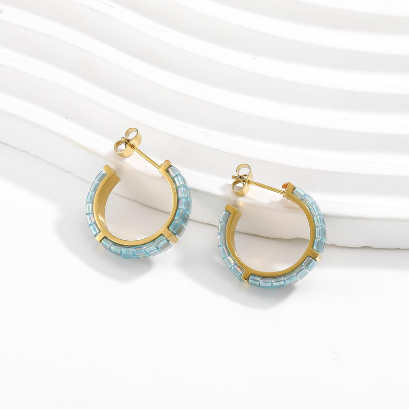 Gold hoop earrings with blue beads on a white background